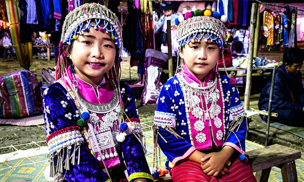 Two hill tribe girls wearing traditional clothing in Thailand.